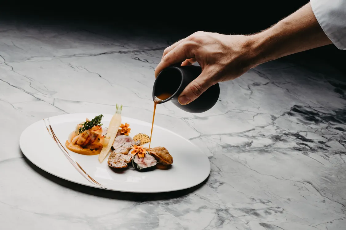 Assiette gastronomique dressée sur une table de restaurant